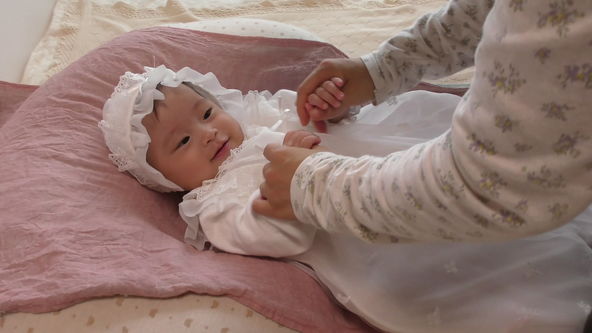 Cute baby model wearing a white lace baby dress.