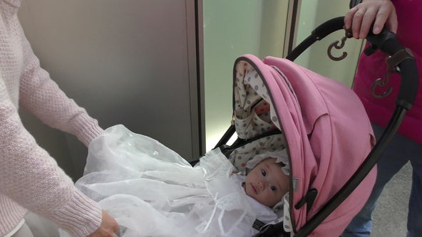 Cute baby model wearing a white lace baby dress. Go out riding on the pink stroller.