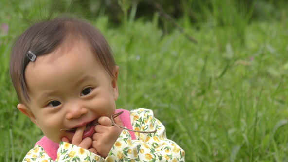 Baby is a happy mood in the spring of the field.