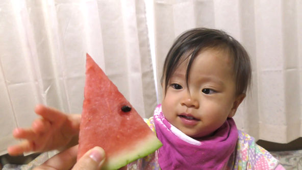 Cute Funny baby eats watermelon for the first time. She see a watermelon for the first time. She put out a hand to a watermelon. She happily.