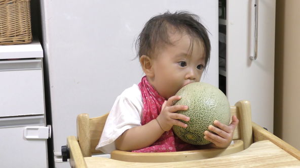 Funny Baby!! This is not a melon bun. It is a real melon. A little scary face.